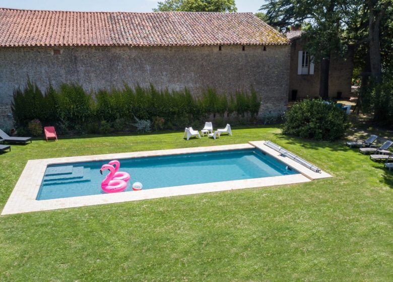 Foto muebles de piscina y casa trasera.